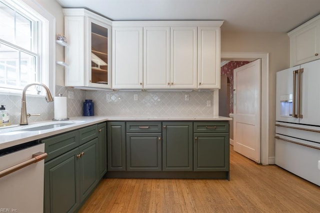 kitchen featuring white appliances, green cabinetry, a sink, and white cabinets