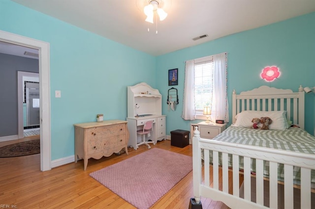 bedroom featuring light wood-type flooring, baseboards, and ceiling fan