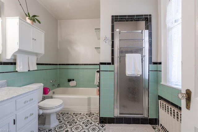 full bathroom with radiator, tile walls, a shower stall, tile patterned floors, and a garden tub
