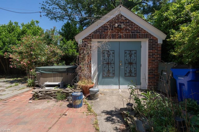 view of outdoor structure with a hot tub and french doors