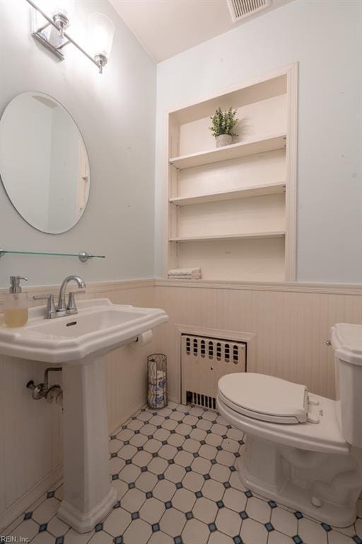 bathroom featuring radiator, a wainscoted wall, toilet, and tile patterned floors