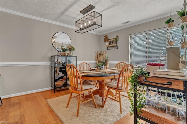 3032 Cape Henry Ct, Virginia Beach, VA 23451 - dining room with a textured ceiling, ornamental molding, light wood finished floors, wainscoting, and a chandelier