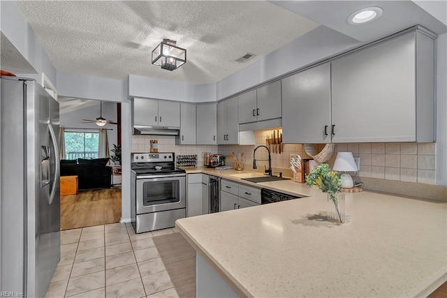 3032 Cape Henry Ct, Virginia Beach, VA 23451 - kitchen with appliances with stainless steel finishes, under cabinet range hood, a sink, a peninsula, and gray cabinetry