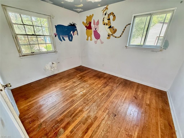 empty room featuring hardwood / wood-style floors and baseboards