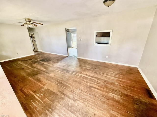 unfurnished living room featuring wood finished floors, a ceiling fan, and baseboards