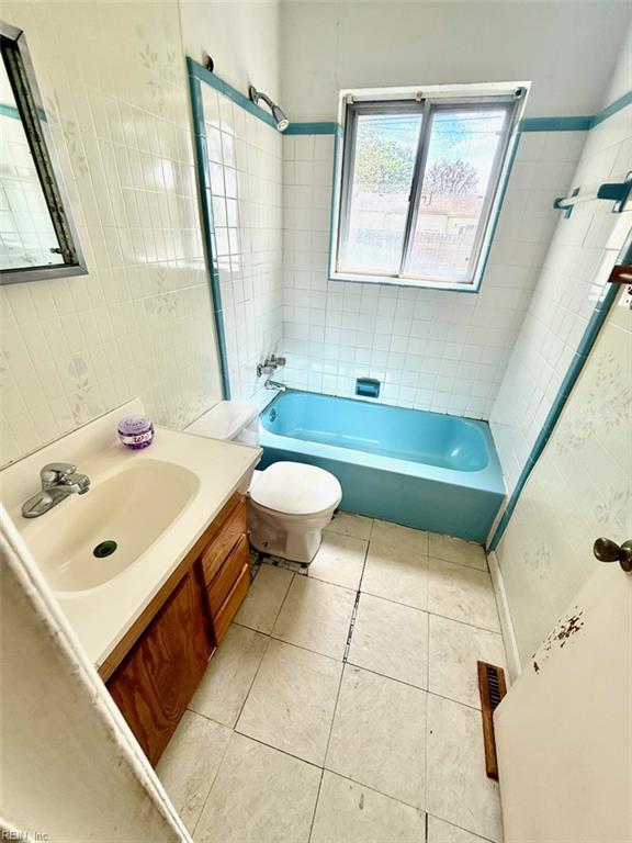 bathroom with tile patterned flooring, toilet, vanity, and bathtub / shower combination