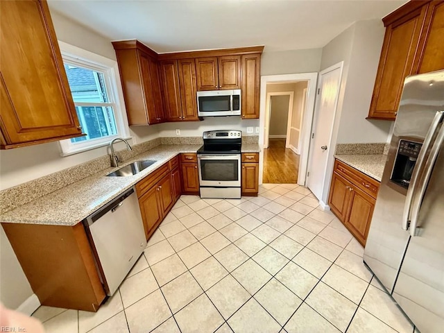 3900 Gosnold Ave, Norfolk, VA 23508 - kitchen featuring stainless steel appliances, a sink, brown cabinetry, and light tile patterned floors