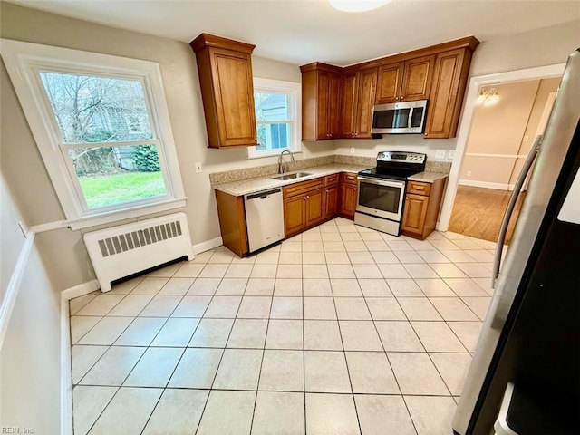 3900 Gosnold Ave, Norfolk, VA 23508 - kitchen featuring appliances with stainless steel finishes, radiator heating unit, a sink, brown cabinets, and plenty of natural light