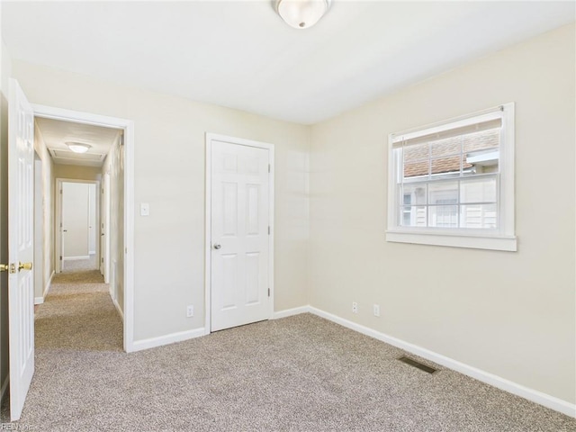 unfurnished bedroom featuring carpet and baseboards