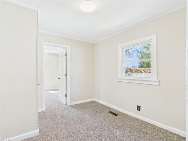 carpeted empty room with crown molding and baseboards