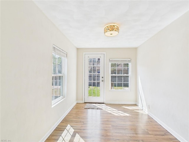 entryway featuring healthy amount of natural light, wood finished floors, and baseboards