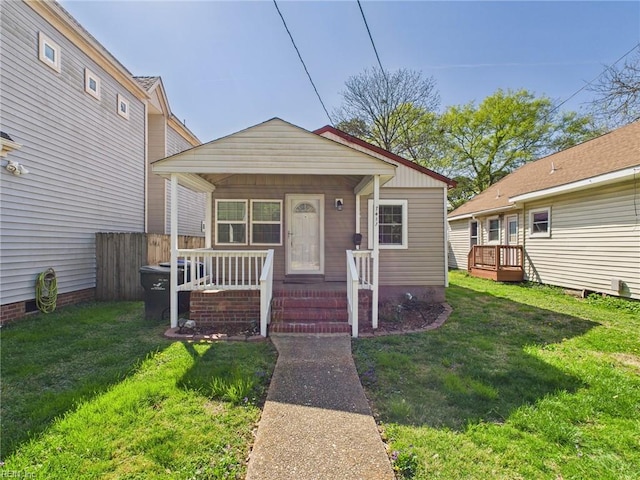 bungalow-style home featuring covered porch and a front yard