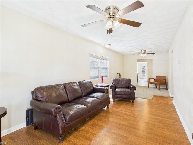 living area with ceiling fan, light wood-type flooring, and baseboards