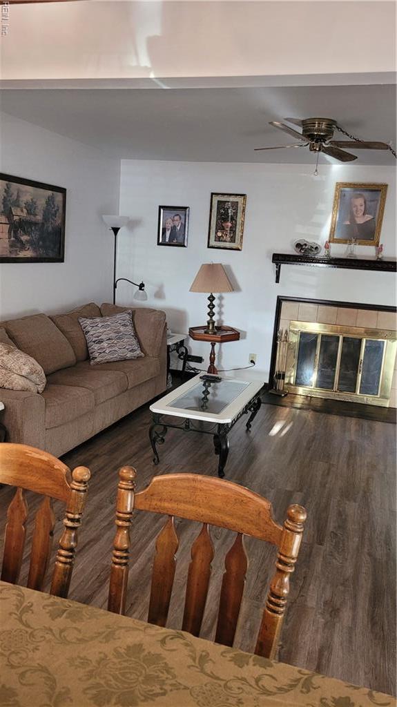 living room featuring wood finished floors, a tile fireplace, and ceiling fan