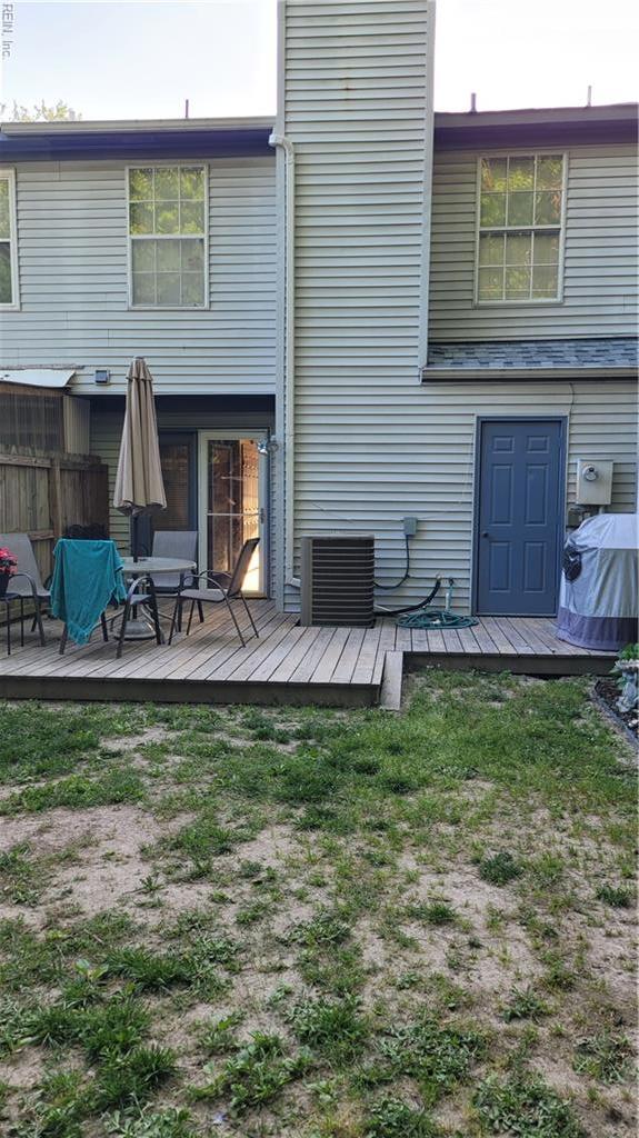 back of property with fence, a wooden deck, and central air condition unit