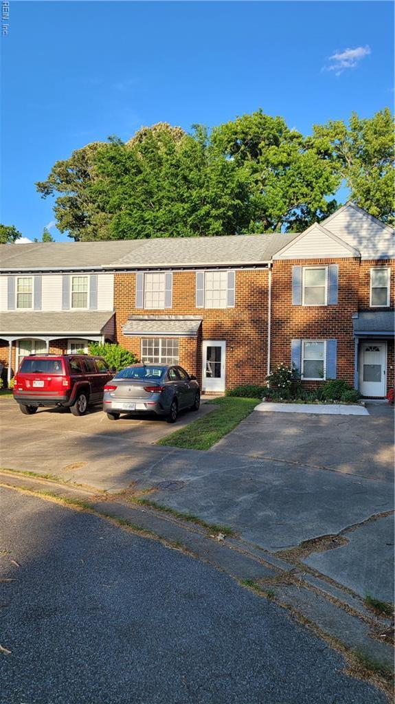 view of front of house featuring uncovered parking and brick siding