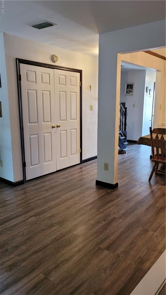 foyer entrance featuring dark wood-style floors and baseboards