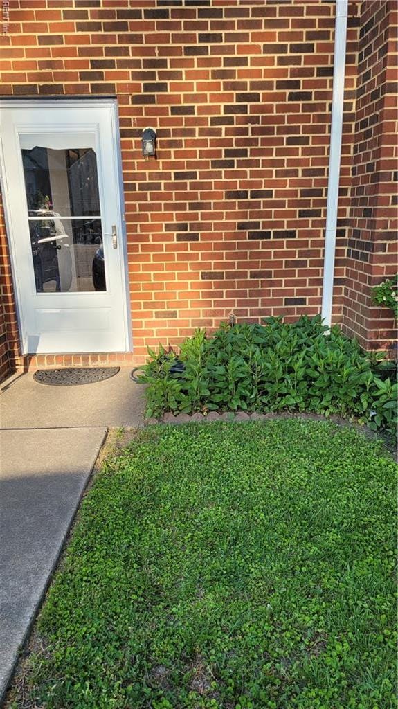 doorway to property with brick siding