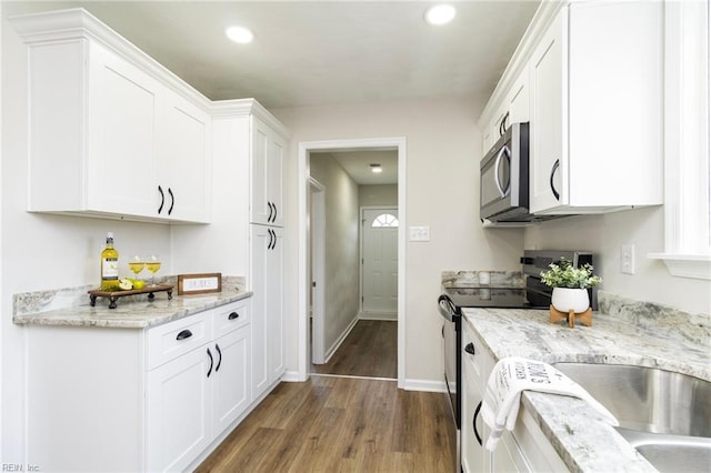 kitchen featuring appliances with stainless steel finishes, dark wood-style flooring, white cabinetry, recessed lighting, and baseboards
