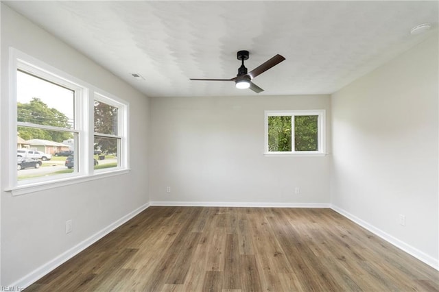 unfurnished room featuring ceiling fan, wood finished floors, and baseboards