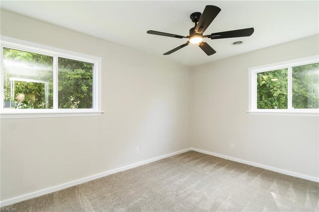 unfurnished room with healthy amount of natural light, carpet floors, baseboards, and a ceiling fan