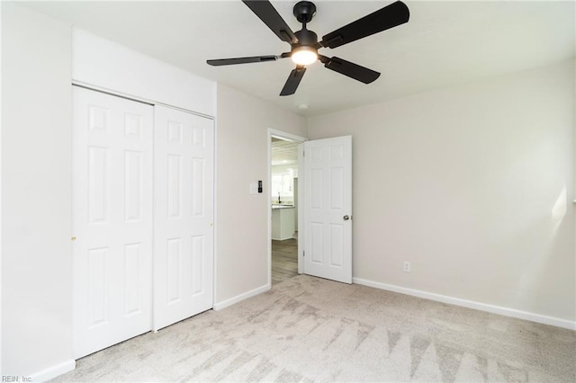 unfurnished bedroom with carpet floors, baseboards, a closet, and ceiling fan