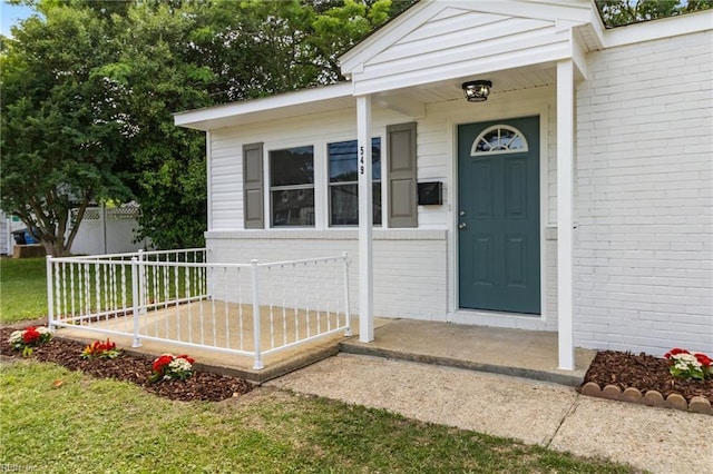 entrance to property featuring brick siding