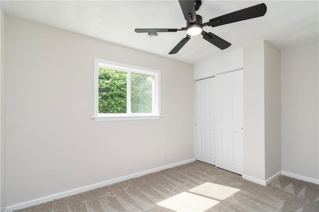 unfurnished bedroom with carpet, baseboards, a closet, and ceiling fan