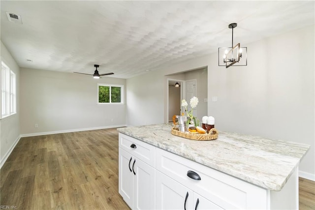 kitchen featuring ceiling fan, light wood-style flooring, white cabinets, pendant lighting, and baseboards