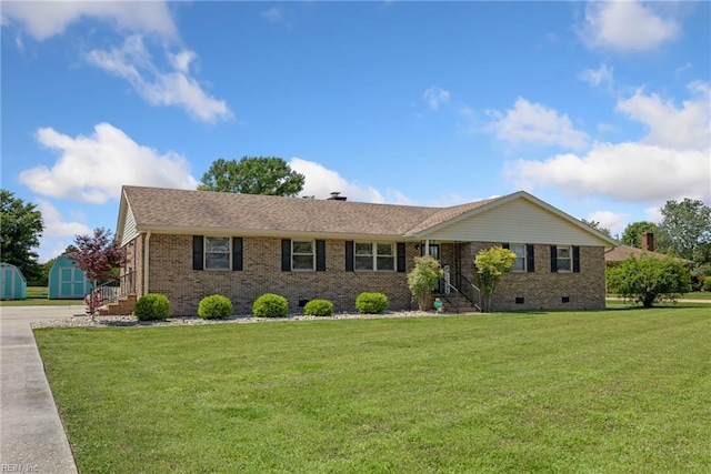 ranch-style house featuring brick siding, a shed, crawl space, and a front yard