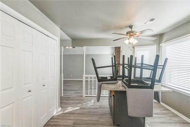 dining space with ceiling fan, baseboards, and light wood-style floors