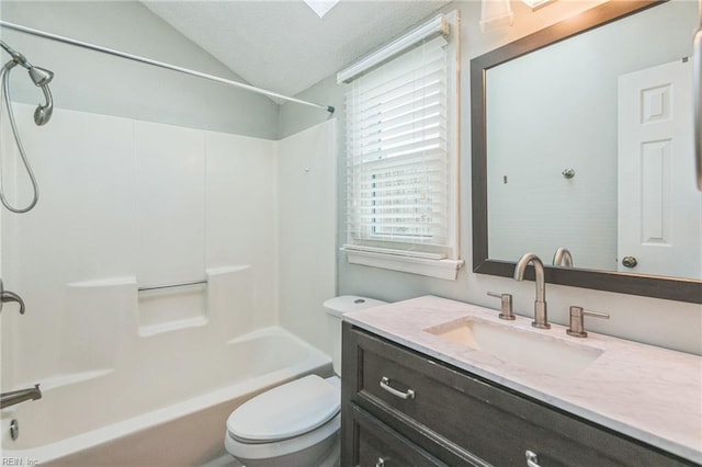 bathroom with toilet, vaulted ceiling, vanity, and shower / washtub combination