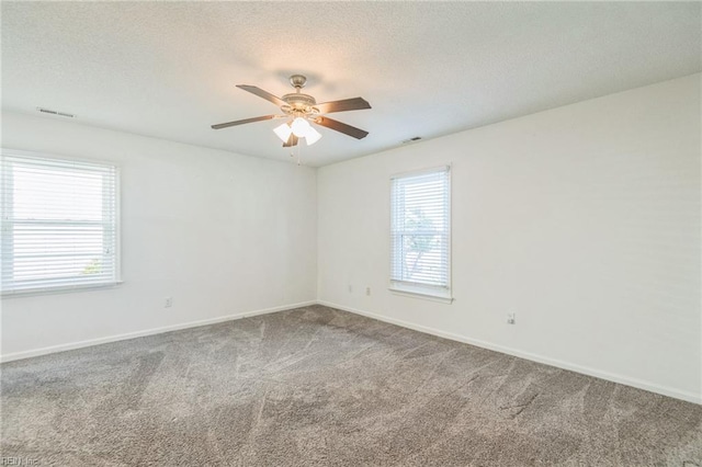 spare room with carpet flooring, a textured ceiling, ceiling fan, and baseboards