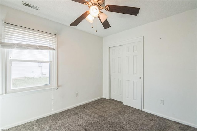 unfurnished bedroom featuring carpet, a closet, baseboards, and a ceiling fan