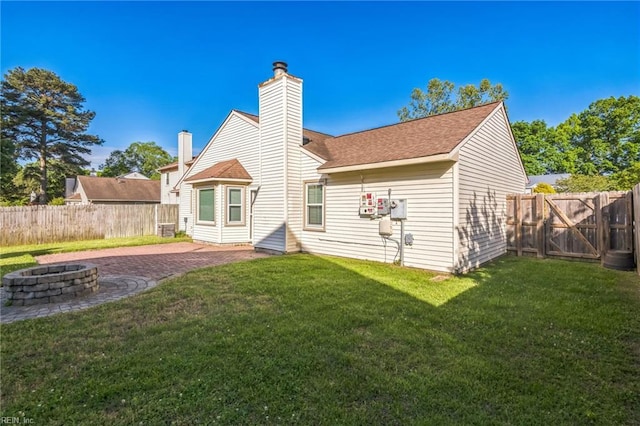 back of property featuring an outdoor fire pit, a chimney, a patio, and a shingled roof
