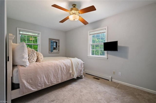 carpeted bedroom with a baseboard heating unit, baseboards, and ceiling fan