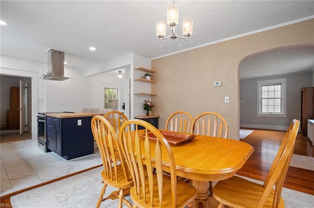 dining space with arched walkways, plenty of natural light, recessed lighting, crown molding, and a chandelier