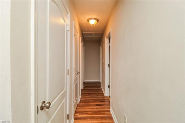hallway with wood finished floors and baseboards