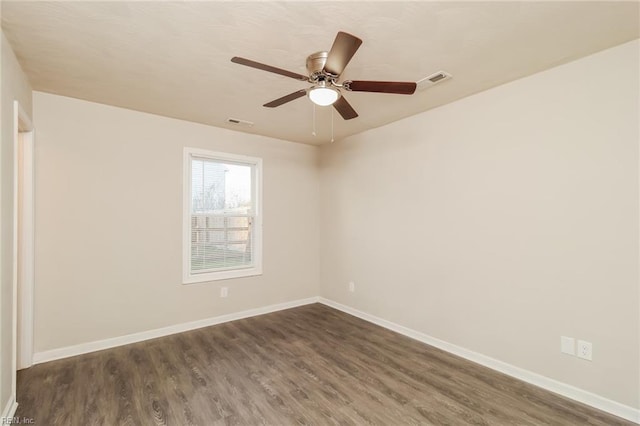 empty room with dark wood finished floors, baseboards, and a ceiling fan