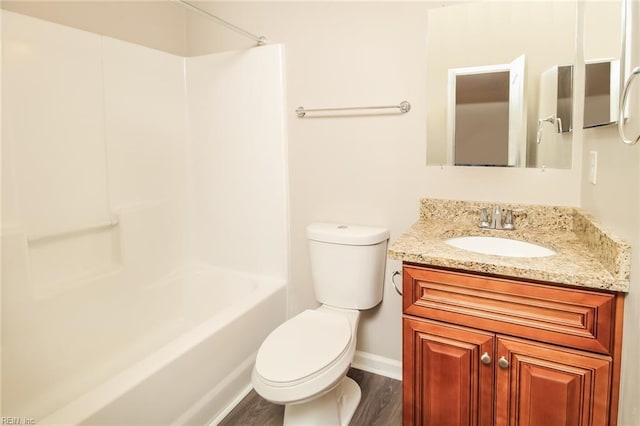 full bathroom featuring wood finished floors, baseboards, toilet, vanity, and washtub / shower combination