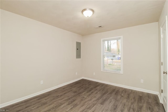 unfurnished room featuring dark wood-style floors, electric panel, and baseboards