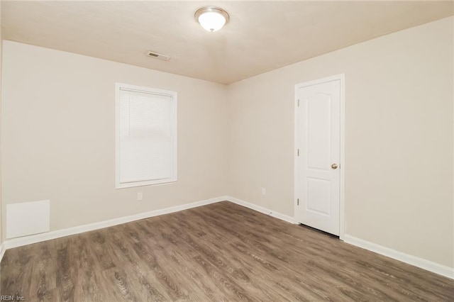 spare room with wood finished floors and baseboards
