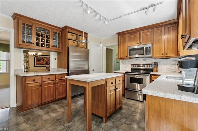 16 Windy Point Dr, Poquoson, VA 23662 - kitchen with stainless steel appliances, brown cabinetry, decorative backsplash, and track lighting