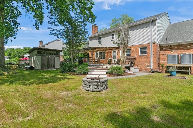 16 Windy Point Dr, Poquoson, VA 23662 - back of property with an outdoor fire pit, a chimney, brick siding, and a yard