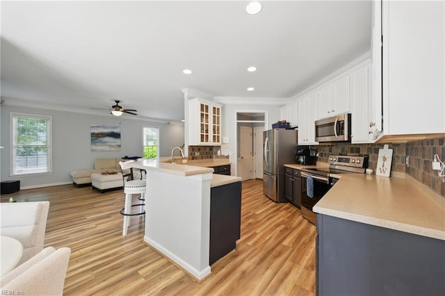 kitchen featuring stainless steel appliances, open floor plan, a breakfast bar, healthy amount of natural light, and recessed lighting
