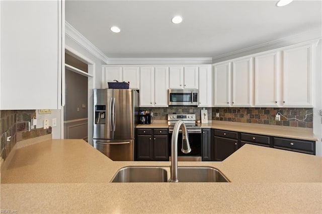kitchen featuring stainless steel appliances, white cabinets, a sink, light countertops, and ornamental molding