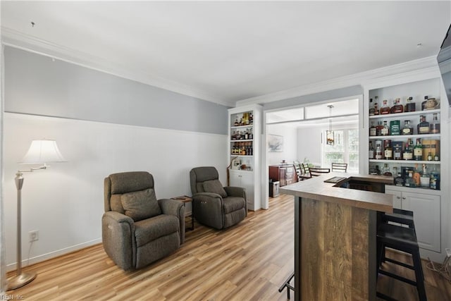 sitting room with light wood-style flooring and crown molding
