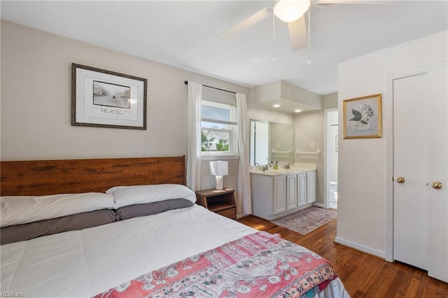 bedroom featuring wood finished floors, connected bathroom, ceiling fan, and a sink