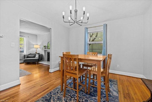 1126 Larchmont Cres, Norfolk, VA 23508 - dining area with a chandelier, wood finished floors, baseboards, and a fireplace with raised hearth