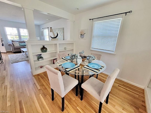 dining area featuring light wood-style flooring and baseboards
